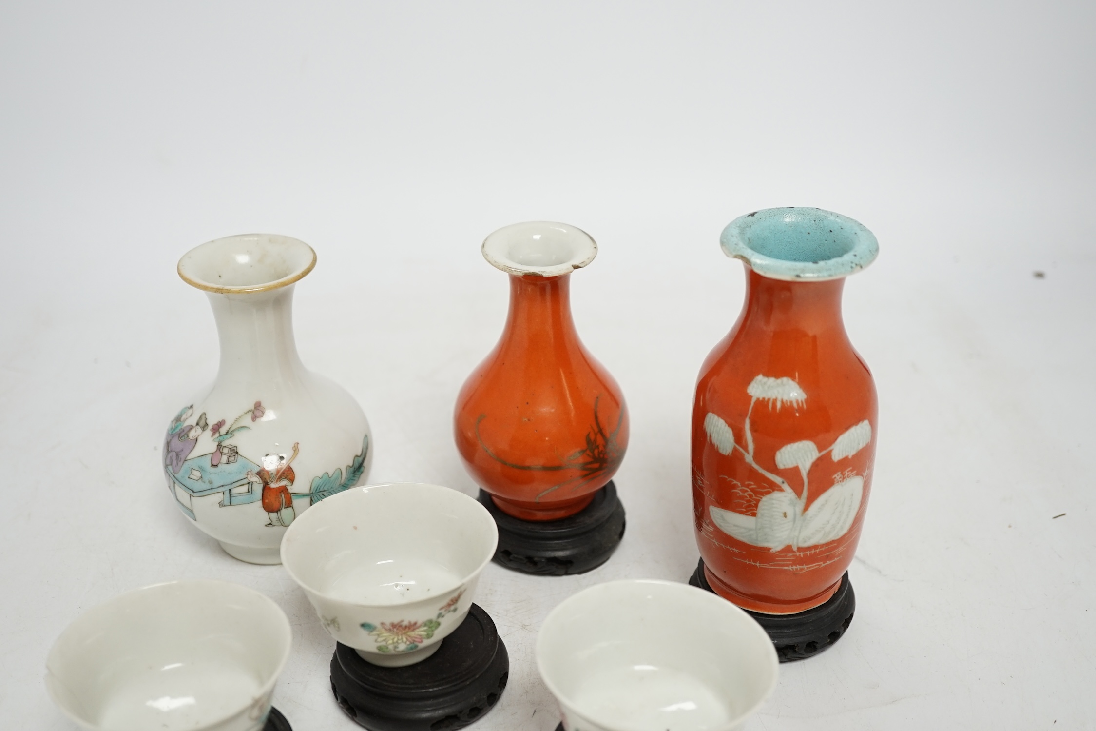 Six Chinese miniature porcelain vases and tea bowls, with wood stands, largest overall 15cm high. Condition - poor to fair